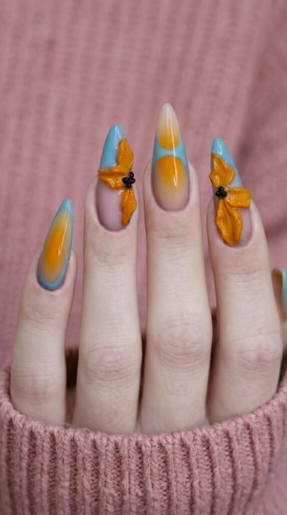 Long stiletto nails with pink blue orange ombre gradient and 3D flower details